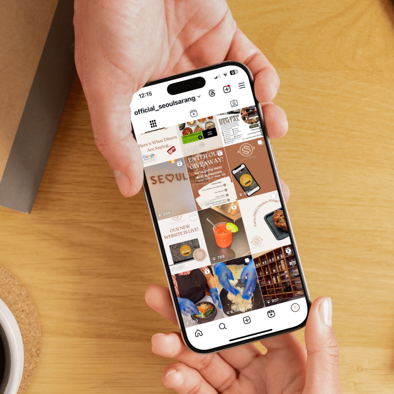 Smartphone showing the @official_seoulsarang Instagram feed with food photography, giveaway posts, and branded content, held over a wooden table.